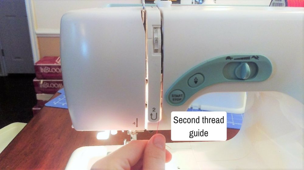Instructions on how to thread your sewing machine - showing the second thread guide