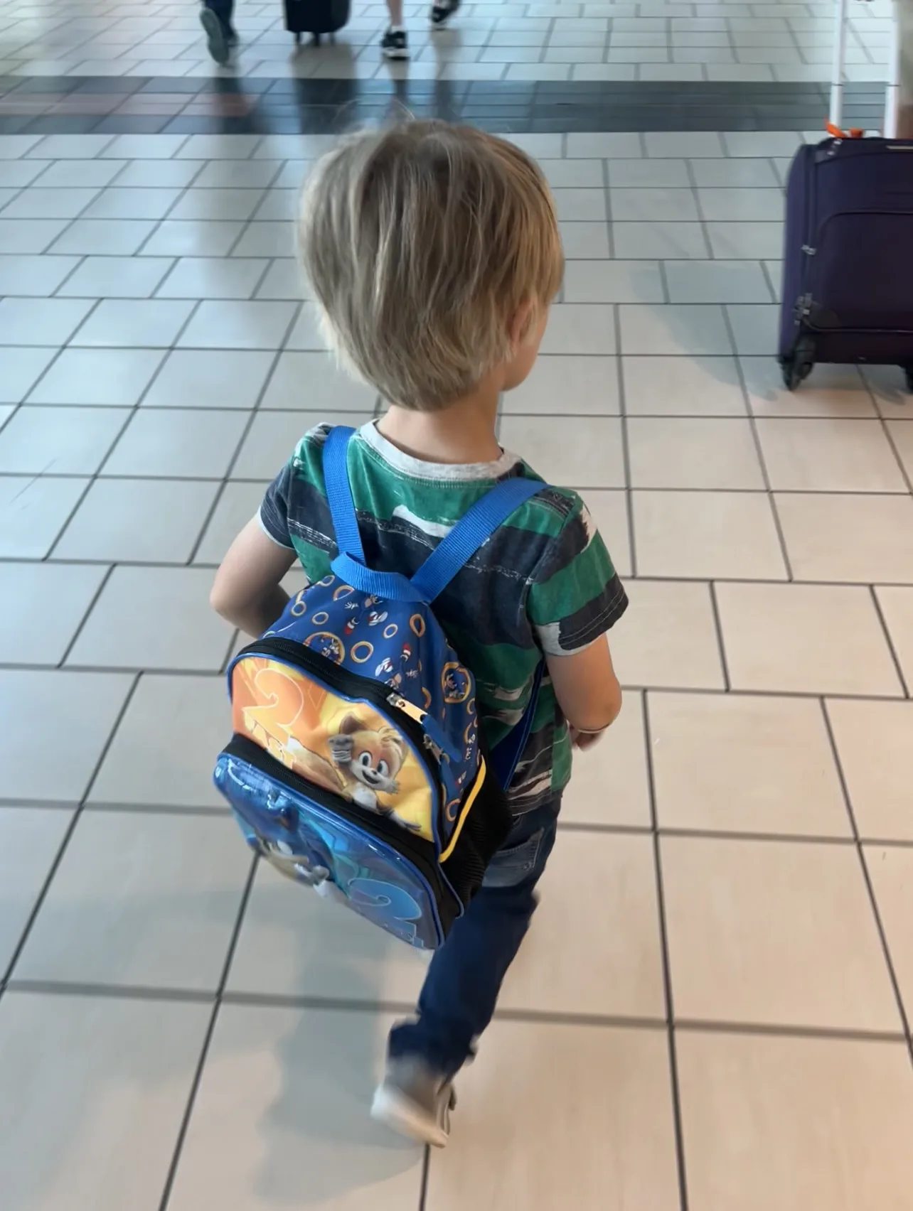 child wearing a backpack - toddler travel essentials